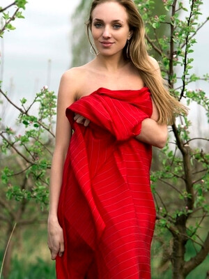 Tayra A playfully posing with a bright red fabric wrapped around her delicate, naked body
